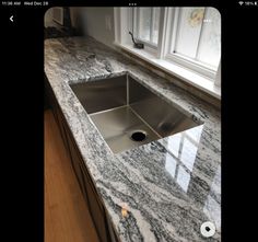 a kitchen counter top with a sink and window