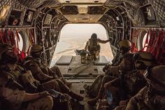 a group of soldiers sitting in the back of an aircraft with their hands on their hipss