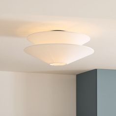 three lights are hanging from the ceiling in a room with white walls and blue cabinets