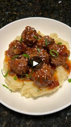 a white plate topped with meatballs and mashed potatoes