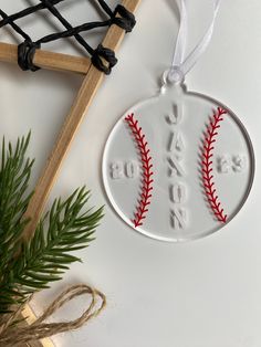 a baseball ornament with the name aaron's on it next to a plant