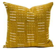 a yellow pillow with white lines and dots on the front, against a white background