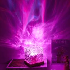 a purple light shines brightly in the background as it sits on top of a book