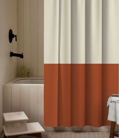 an orange and white shower curtain in a bathroom with a bathtub next to it