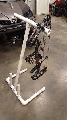 an upside down bike rack in a garage next to a parked motorcycle and other vehicles