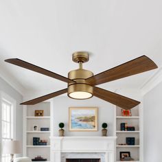 a ceiling fan in a living room with a fireplace and built - in bookshelves