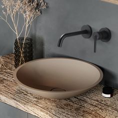 a bathroom sink sitting on top of a counter next to a vase with flowers in it