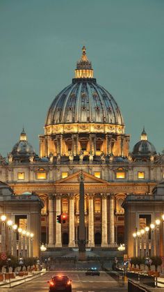 a large building with a dome and lights on it's sides at night time