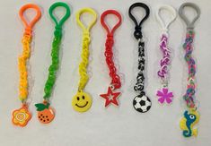 several different colored lanyards are lined up on a white surface, one has a smiley face and the other has a starfish