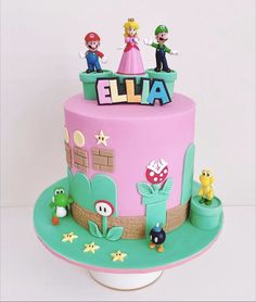 a pink cake with mario and princess peaches on it's top is decorated in fondant