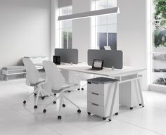 an office desk with two chairs and a laptop computer on it, in front of a large window