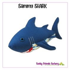 a blue stuffed shark with teeth on it's back and the words, funny friends factory