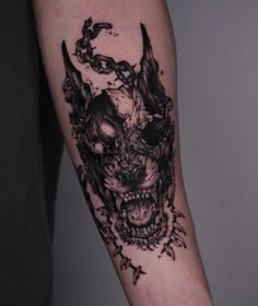 a black and white tattoo on the arm of a man with a demon head design