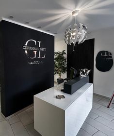 a white counter in front of a black and white wall with the words gldl on it