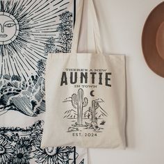 a tote bag sitting on top of a table next to a hat