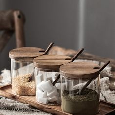 three jars filled with marshmallows on top of a wooden tray