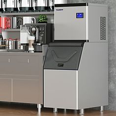 a coffee machine sitting on top of a counter next to a shelf filled with cups