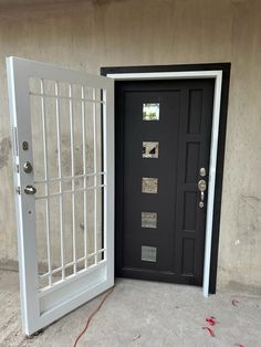 a black door with bars on the side and a white gate in front of it