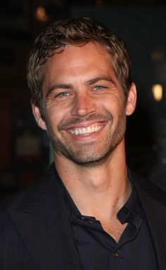 a man smiling and wearing a black shirt