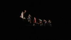 a group of people playing basketball in the dark