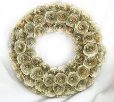 a wreath made out of rolled up flowers on a white sheet with the word love written in it