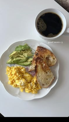 a white plate topped with eggs, toast and avocado next to a cup of coffee