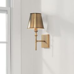 a wall light that is on the side of a white wall next to a window