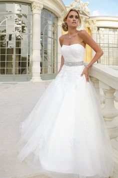 a woman in a white wedding dress posing for the camera