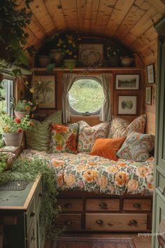 a living room filled with lots of furniture and flowers on the window sill next to a sink