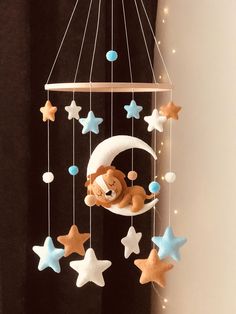 a baby crib mobile with a teddy bear on the moon and stars hanging from it