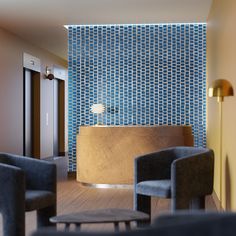 a hotel lobby with chairs and a reception desk in front of a blue tiled wall