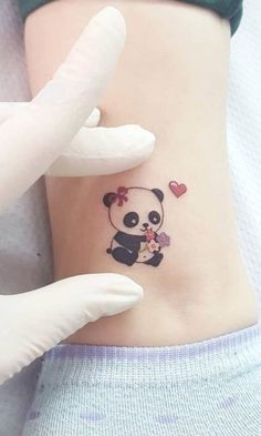 a small panda bear tattoo on the side of a woman's right arm and leg