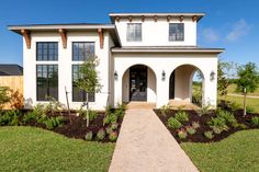 a white house with landscaping in the front yard