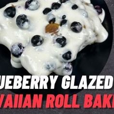 a black plate topped with blueberries and cream