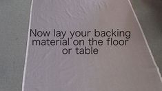 a white towel with black writing on it that says, now lay your backing material on the floor or table