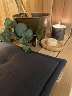 a wooden table topped with a candle next to a potted plant and other items