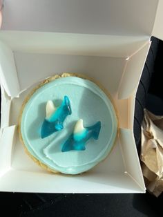 two cookies with blue frosting in a white box