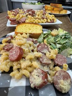 several plates with different types of pasta and meats on them sitting on a table