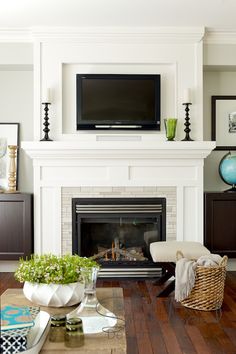 a living room filled with furniture and a flat screen tv mounted above a fire place