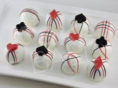 white chocolates with black and red decorations on a plate