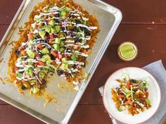 a tray filled with mexican food next to a bowl of guacamole