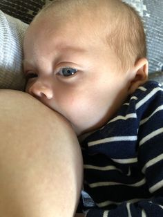 a baby laying on top of someone's lap with his head near the belly