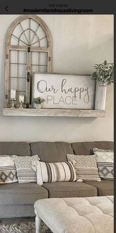 a living room with a couch, ottoman and sign on the wall that says our happy place