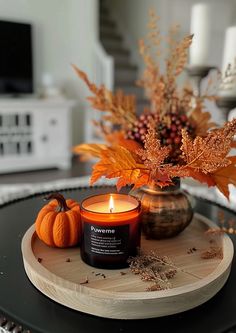 a candle and some pumpkins on a table