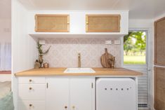 a kitchen with white cabinets and wooden counter tops