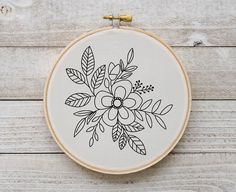 an embroidery hoop with a black and white flower on it