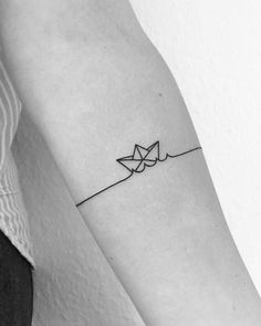 a black and white photo of a person's arm with an origami tattoo on it