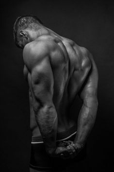 a man with his back turned to the camera, showing off his muscular body and muscles