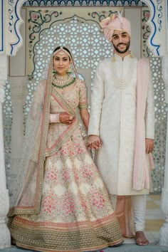 two people standing next to each other in wedding outfits