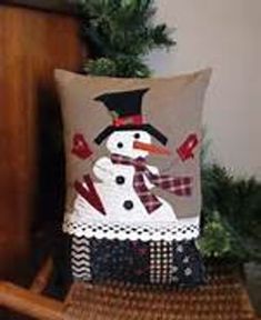 a snowman pillow sitting on top of a wooden chair